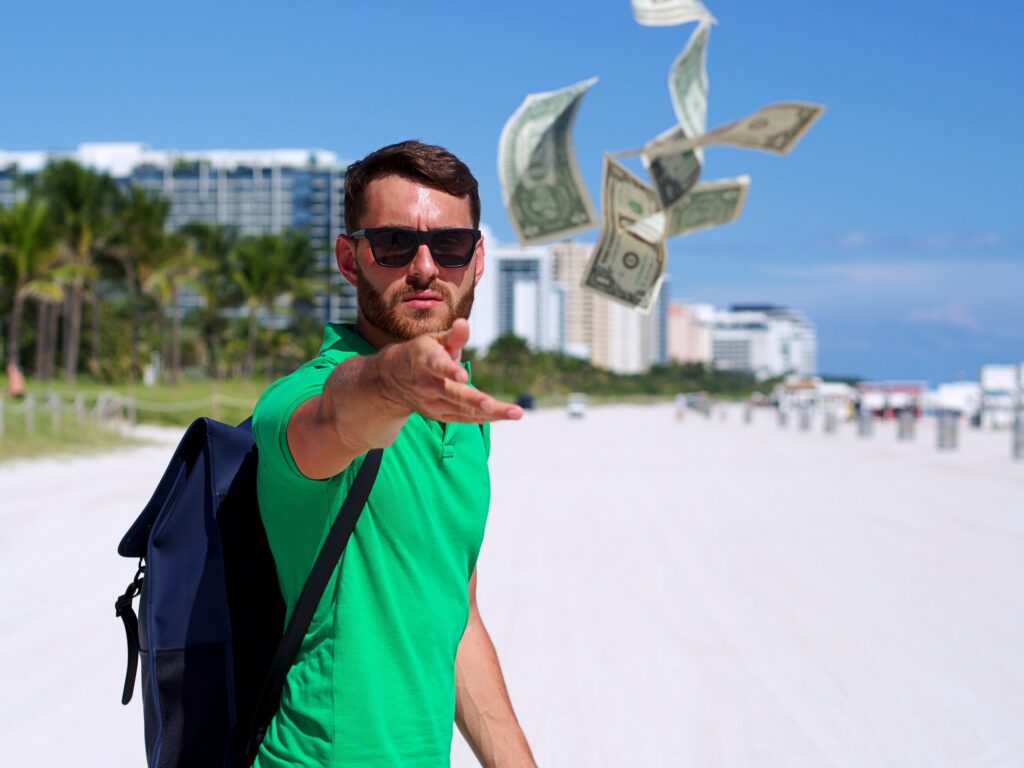 Man throwing money away on south beach miami money flying